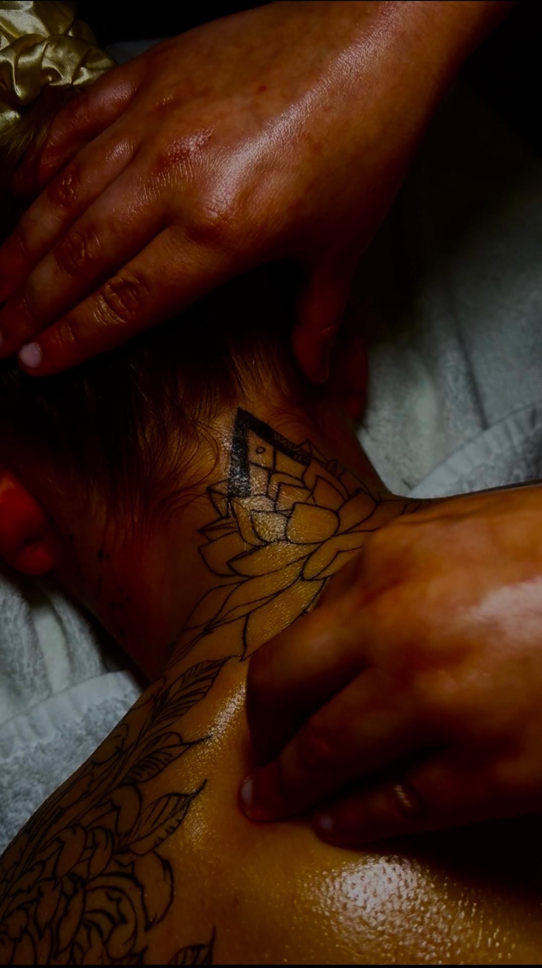 Therapist working along the neck and shoulders during a massage